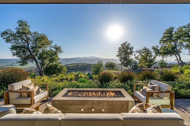view of patio featuring an outdoor living space with a fire pit and a mountain view