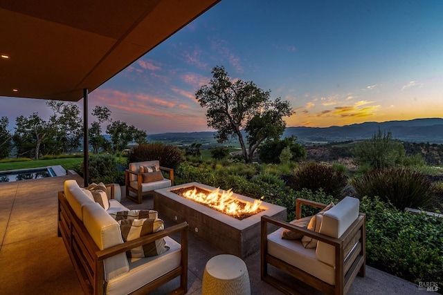 view of patio featuring a mountain view and an outdoor living space with a fire pit