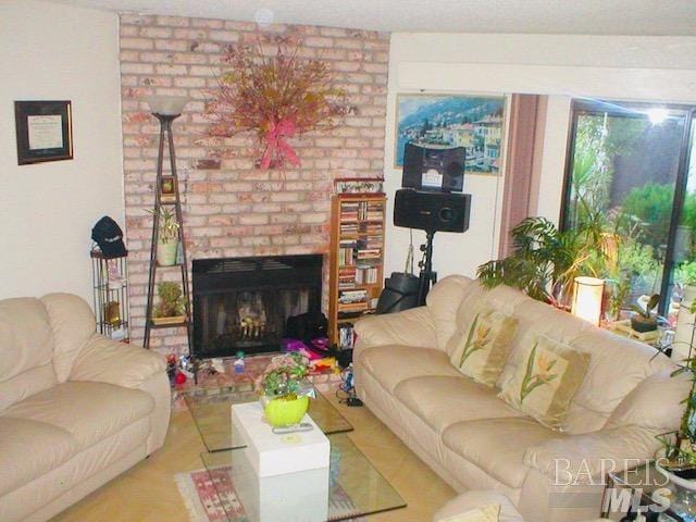 living room featuring brick wall and a fireplace