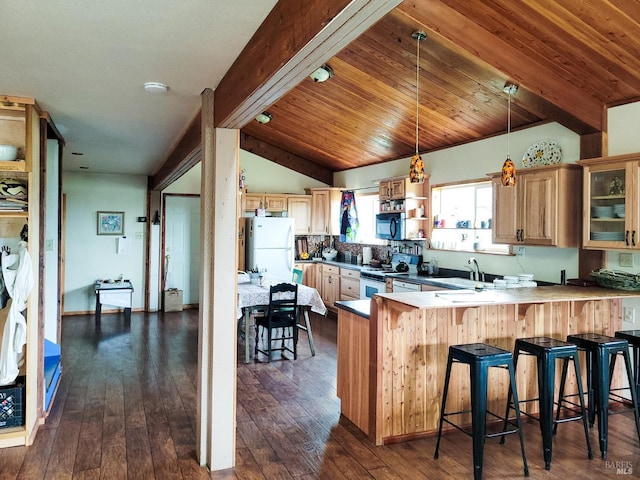 kitchen featuring a breakfast bar, white appliances, sink, decorative light fixtures, and kitchen peninsula