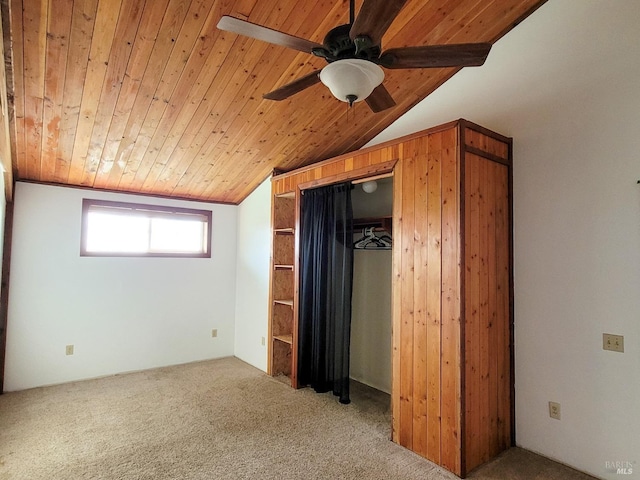 unfurnished bedroom with carpet, a closet, lofted ceiling, and wooden ceiling