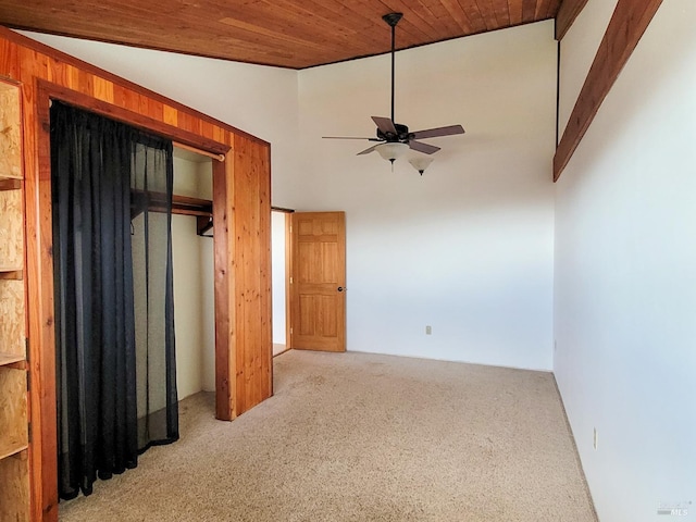 unfurnished bedroom with light carpet, wood ceiling, ceiling fan, a closet, and lofted ceiling