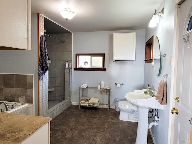 bathroom with tiled shower and toilet