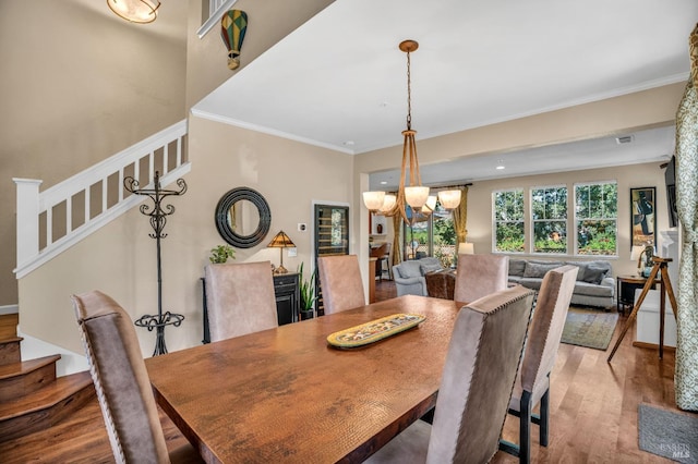 dining area featuring crown molding, an inviting chandelier, and wood-type flooring