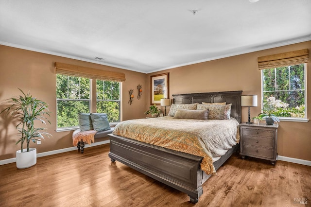 bedroom with crown molding and hardwood / wood-style flooring