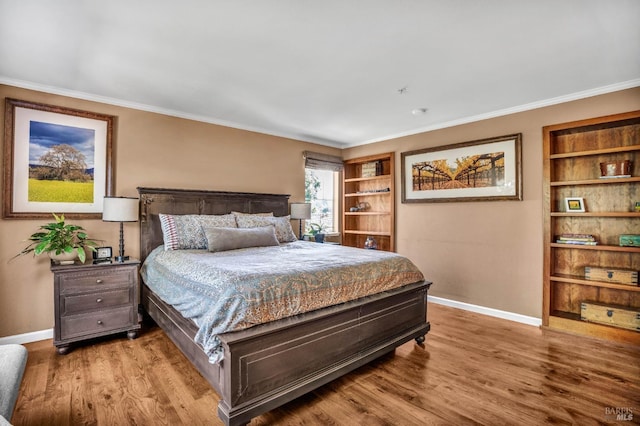 bedroom with crown molding and light wood-type flooring