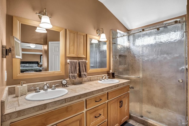 bathroom featuring walk in shower, ceiling fan, dual sinks, large vanity, and lofted ceiling