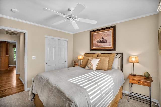 bedroom with ceiling fan, crown molding, and a closet