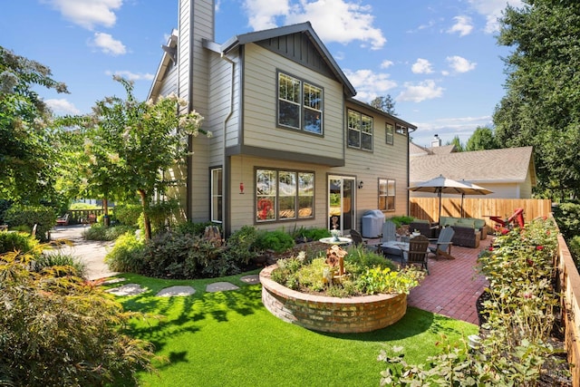 rear view of property featuring a patio area and a yard