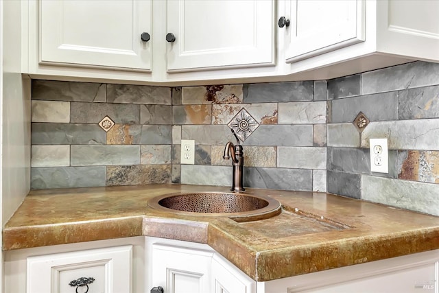 kitchen with sink, tasteful backsplash, and white cabinets