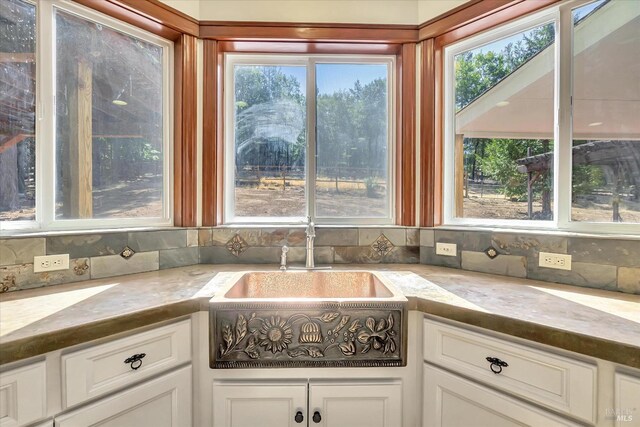 kitchen with white cabinets, sink, and backsplash