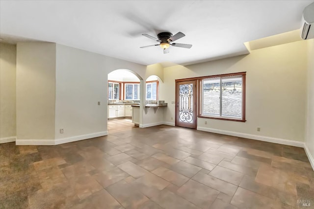 empty room featuring ceiling fan, a wall mounted air conditioner, and tile patterned floors