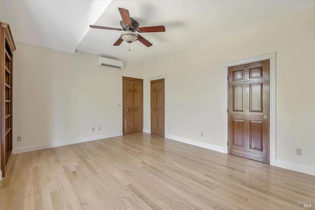 unfurnished bedroom featuring ceiling fan, an AC wall unit, and light hardwood / wood-style floors