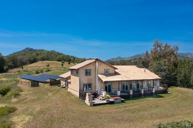 back of house featuring a wooden deck and a lawn