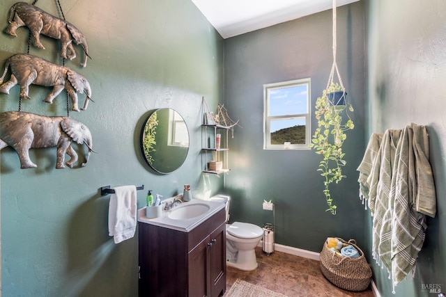 bathroom with toilet, tile floors, and vanity