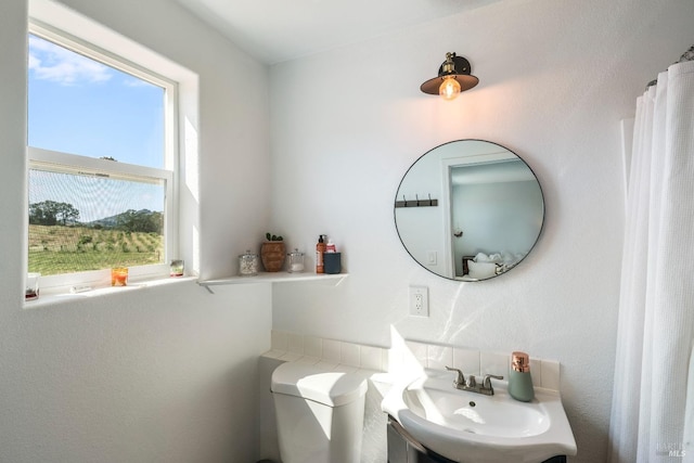 bathroom featuring sink, a healthy amount of sunlight, and toilet