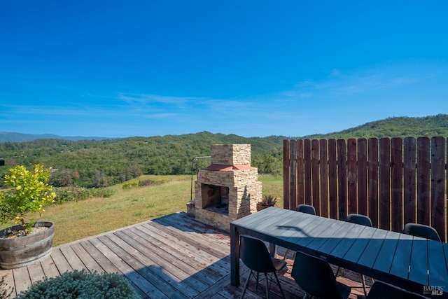 wooden terrace with an outdoor stone fireplace