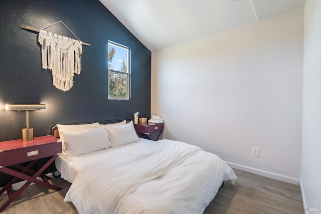 bedroom with lofted ceiling and hardwood / wood-style flooring