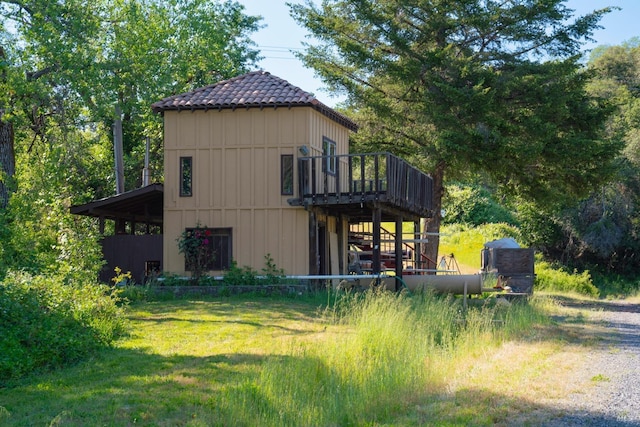 view of side of property with a yard and a wooden deck