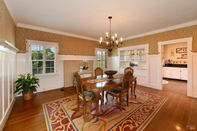 dining area featuring an inviting chandelier, dark wood-type flooring, and ornamental molding