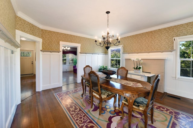 dining space with dark hardwood / wood-style floors, ornamental molding, and a notable chandelier