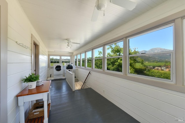 sunroom featuring a mountain view, ceiling fan, and separate washer and dryer