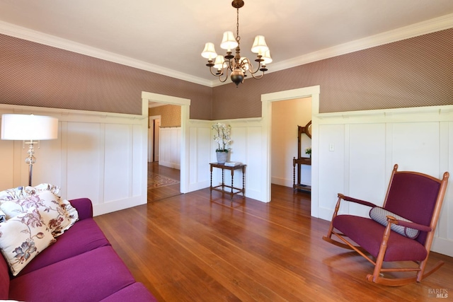 living room with ornamental molding, dark wood-type flooring, and an inviting chandelier