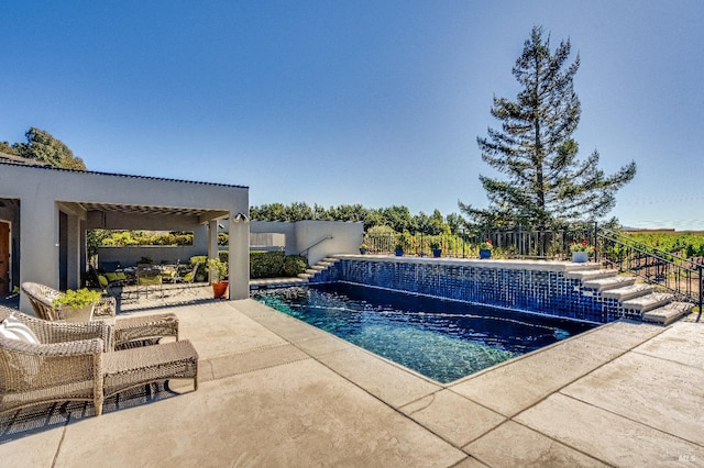 view of swimming pool with pool water feature and a patio