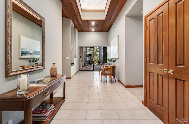 hallway with light tile floors and a skylight