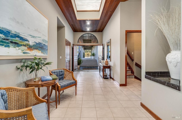 tiled entryway with a skylight and wood ceiling