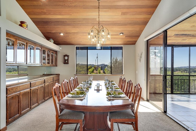 dining space with a notable chandelier, light colored carpet, and a healthy amount of sunlight
