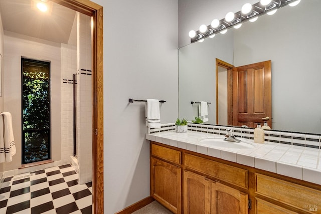 bathroom with tile floors, vanity, and an enclosed shower