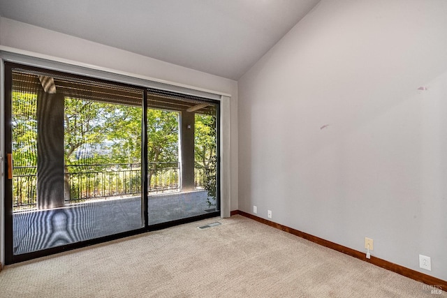 spare room featuring vaulted ceiling and light colored carpet
