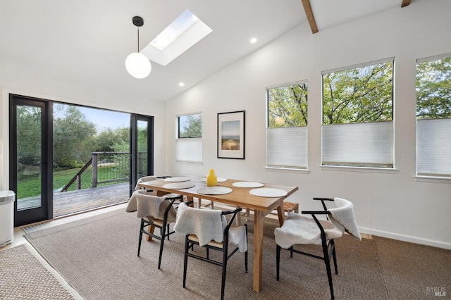 dining room with a skylight, a healthy amount of sunlight, high vaulted ceiling, and beamed ceiling