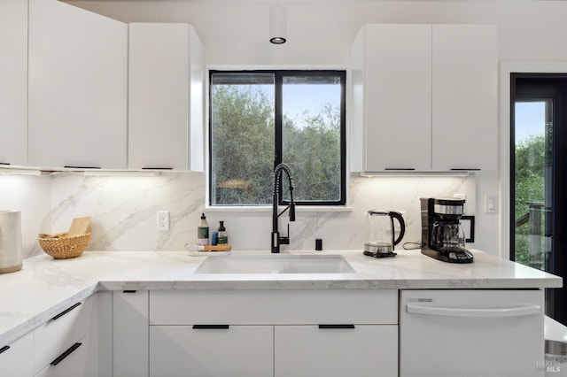 kitchen featuring white cabinetry, a healthy amount of sunlight, tasteful backsplash, and white dishwasher