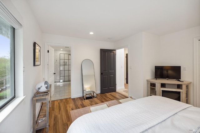 bedroom featuring dark hardwood / wood-style flooring and connected bathroom