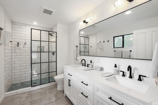 bathroom with a shower with door, dual bowl vanity, tile floors, and toilet