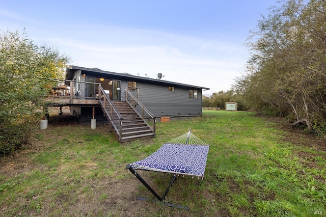 back of house with a deck and a lawn