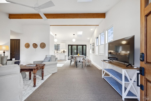 living room featuring light carpet, ceiling fan, and vaulted ceiling with beams