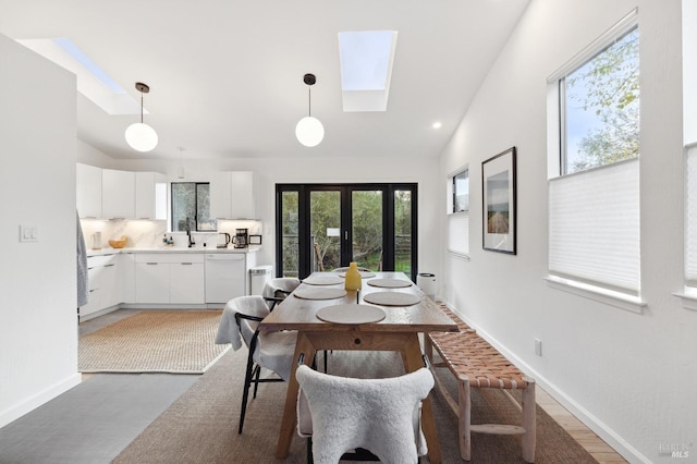 dining area with lofted ceiling with skylight, hardwood / wood-style floors, and a wealth of natural light