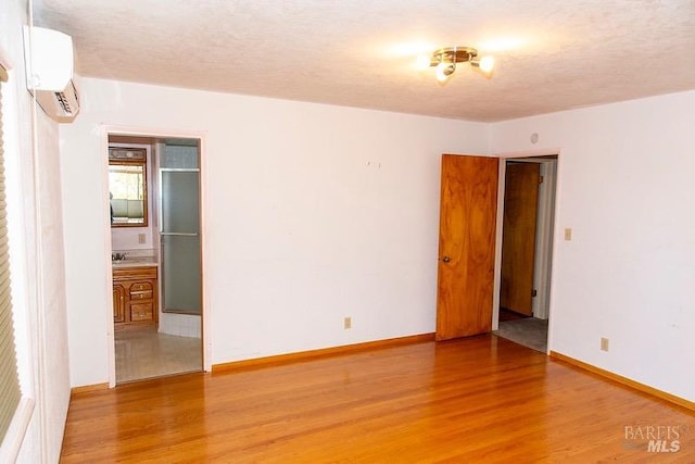 empty room with a wall unit AC and hardwood / wood-style flooring