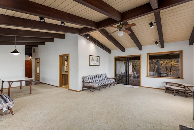 sitting room featuring ceiling fan, carpet floors, and vaulted ceiling with beams