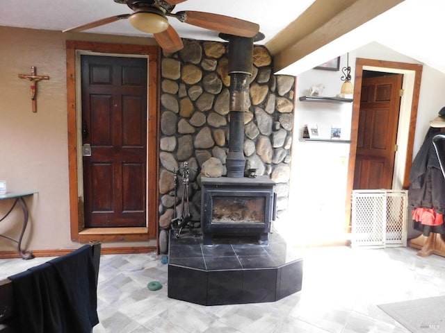 living room with a wood stove and ceiling fan