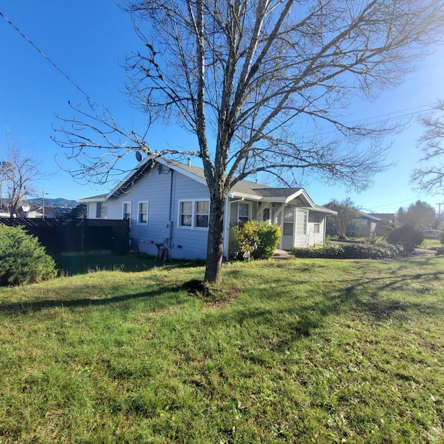 view of side of home with a yard