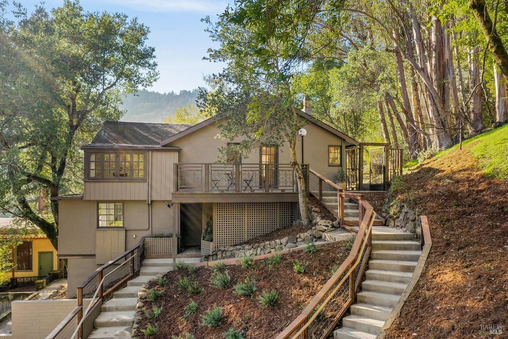 view of front facade featuring stairway and stucco siding