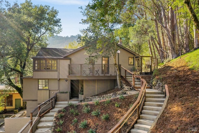 view of front facade featuring stairway and stucco siding
