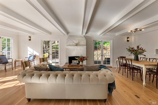 living room with light wood-type flooring, french doors, and beam ceiling