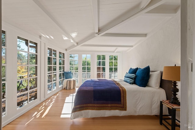 bedroom with hardwood / wood-style flooring and vaulted ceiling with beams