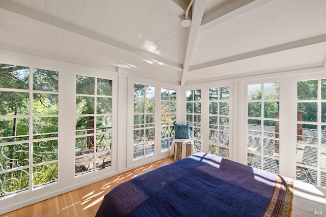 sunroom / solarium featuring vaulted ceiling with beams