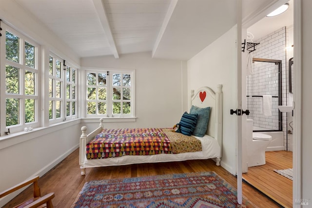 bedroom featuring ensuite bath, wood-type flooring, and lofted ceiling with beams